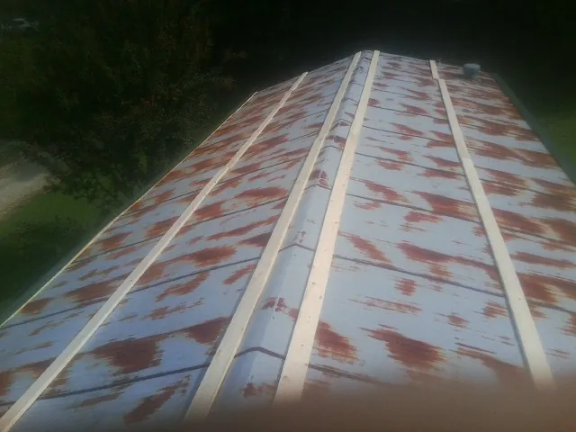 Rusted metal roof panels with new wood purlins before replacement — Storm Damage Roof Repair in Lawn by Roofing Brothers