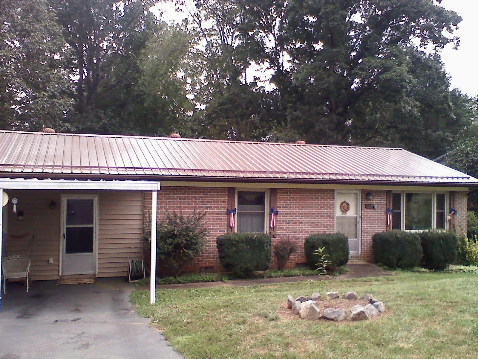 Bronze metal roof and carport on a brick ranch home — Roof Repair work by our crew in Lawn
