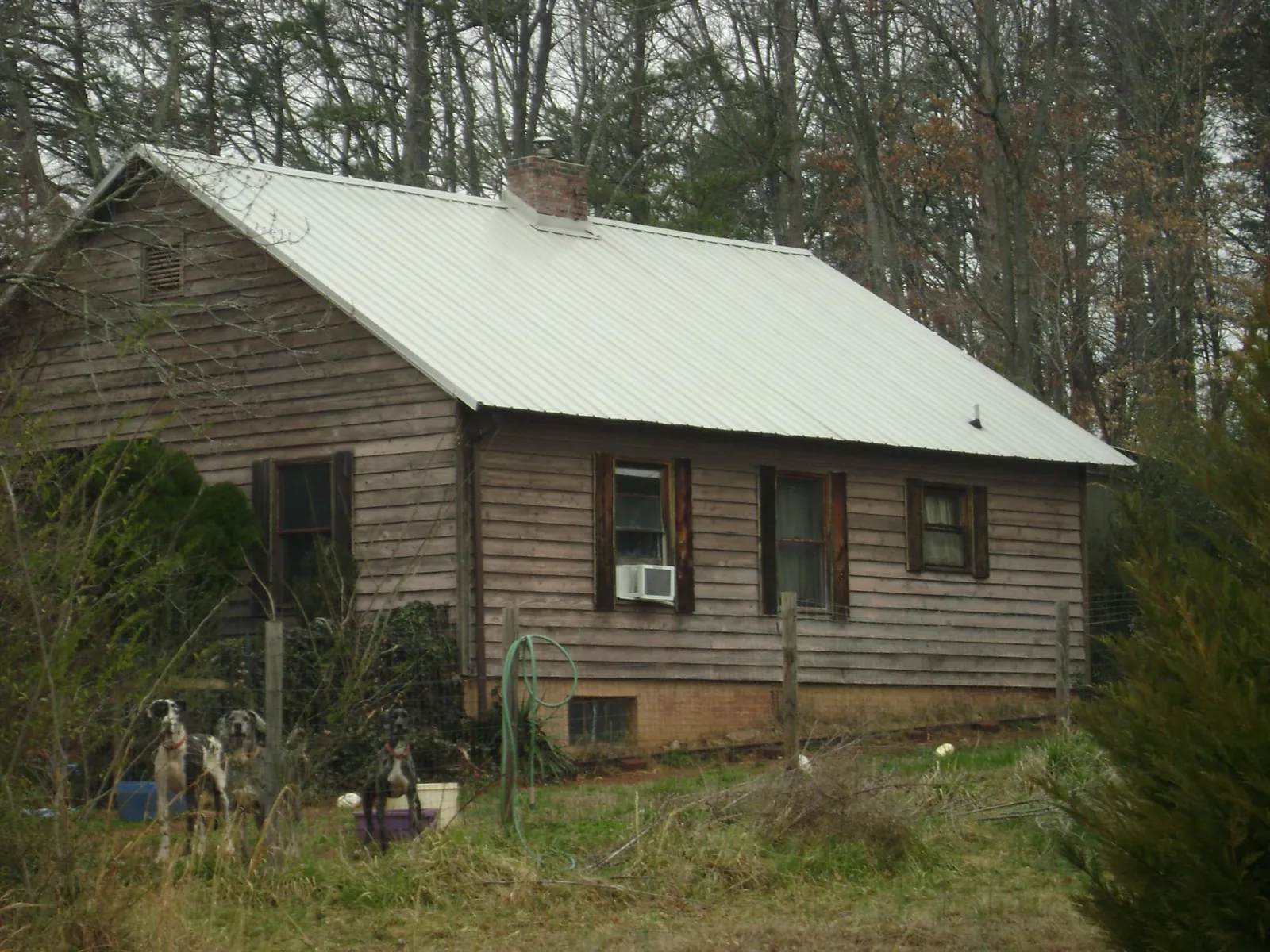 White metal roof on an old wood sided farmhouse, from a Metal Roof Installation job in Lawn